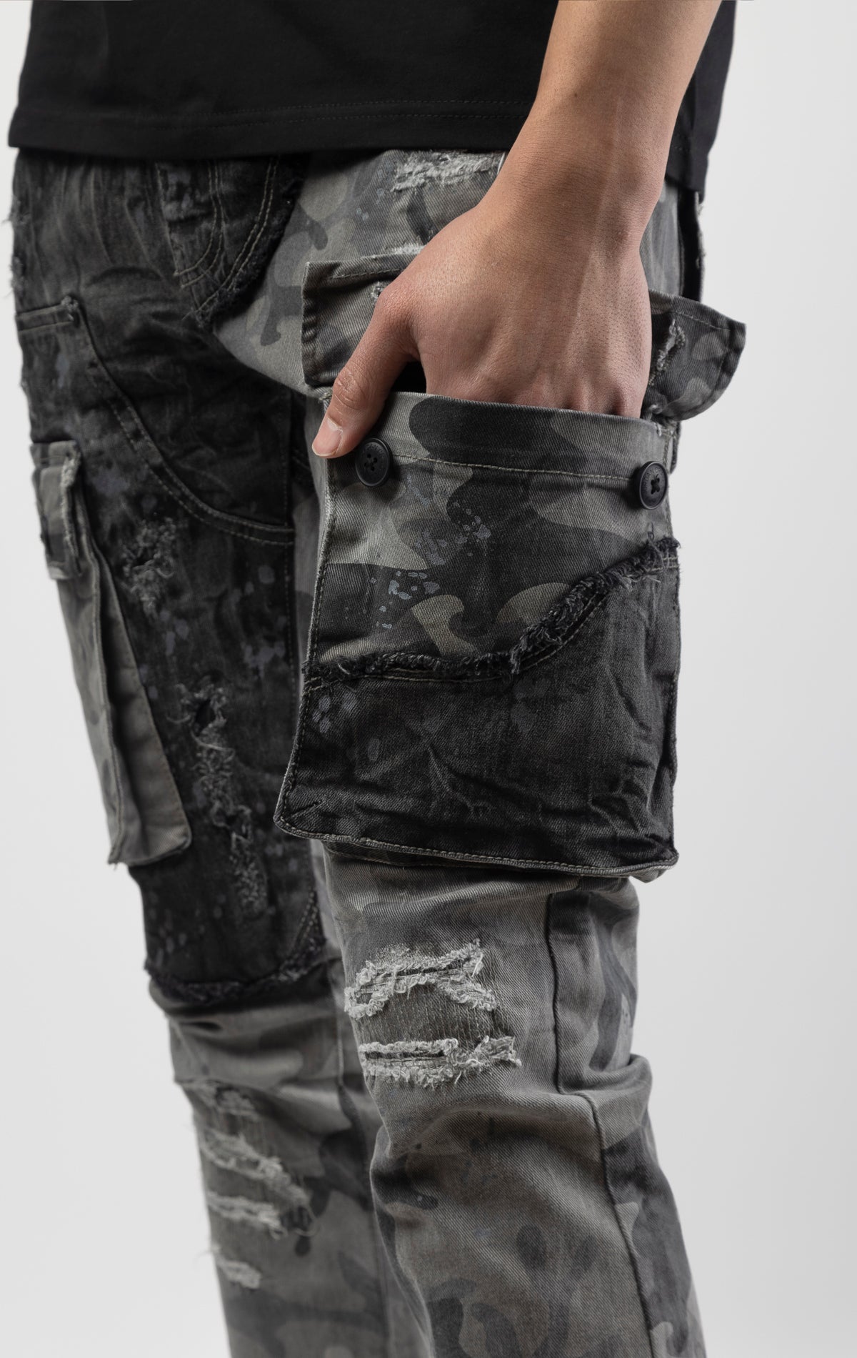 Black camo Extended length flare pant with a regular rise for maximum stacks. Skinny fit with hand-smearing and speckled paint splatter throughout. Rip and repair detailing, accompanied by cut & sewn woodland camouflage twill patches. Stitching repairs an