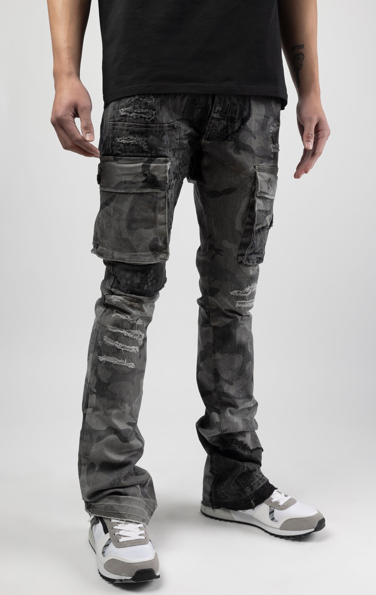 Black camo Extended length flare pant with a regular rise for maximum stacks. Skinny fit with hand-smearing and speckled paint splatter throughout. Rip and repair detailing, accompanied by cut & sewn woodland camouflage twill patches. Stitching repairs an
