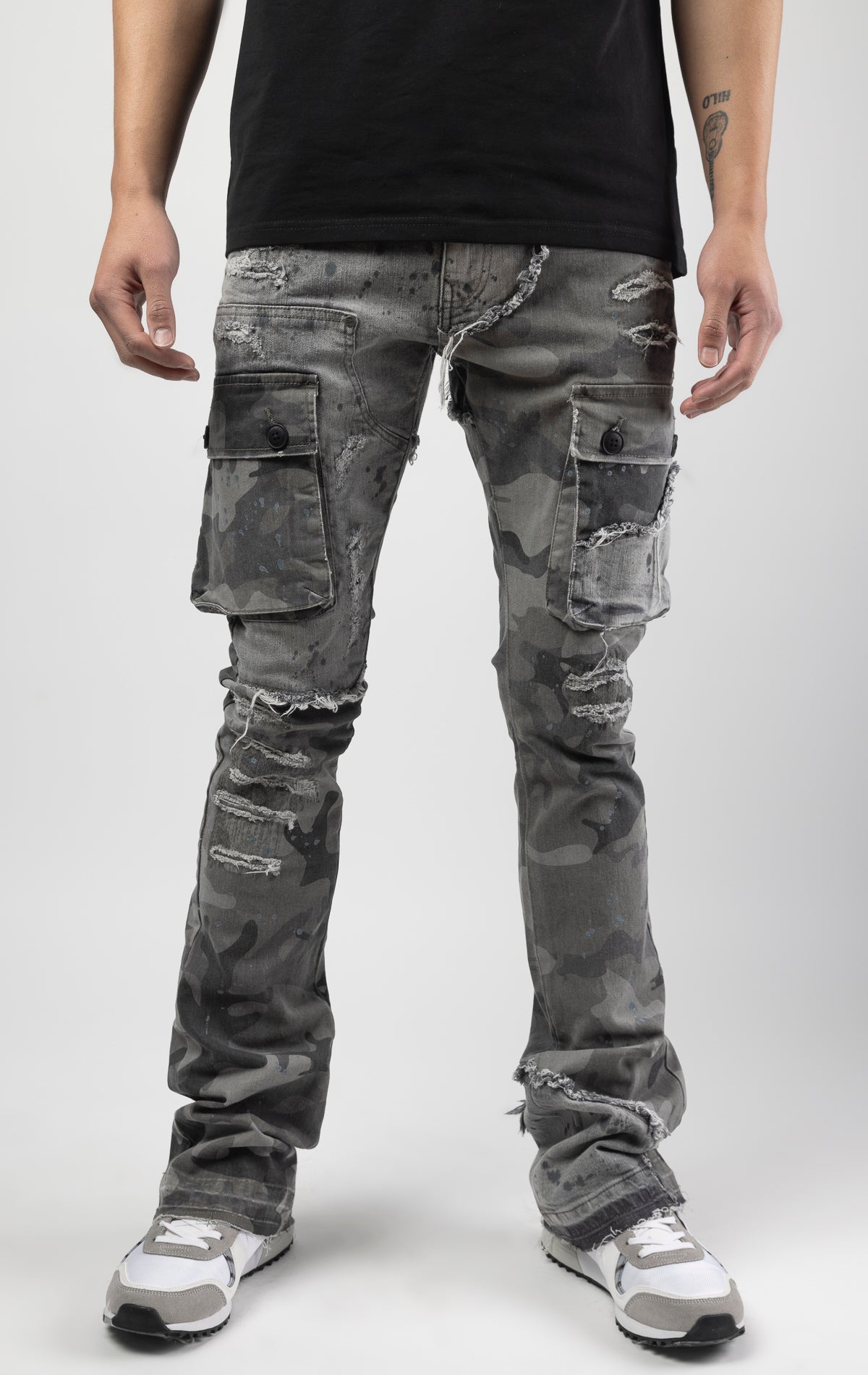 Overcast camo extended length flare pant with a regular rise for maximum stacks. Skinny fit with hand-smearing and speckled paint splatter throughout. Rip and repair detailing, accompanied by cut & sewn woodland camouflage twill patches. Stitching repairs