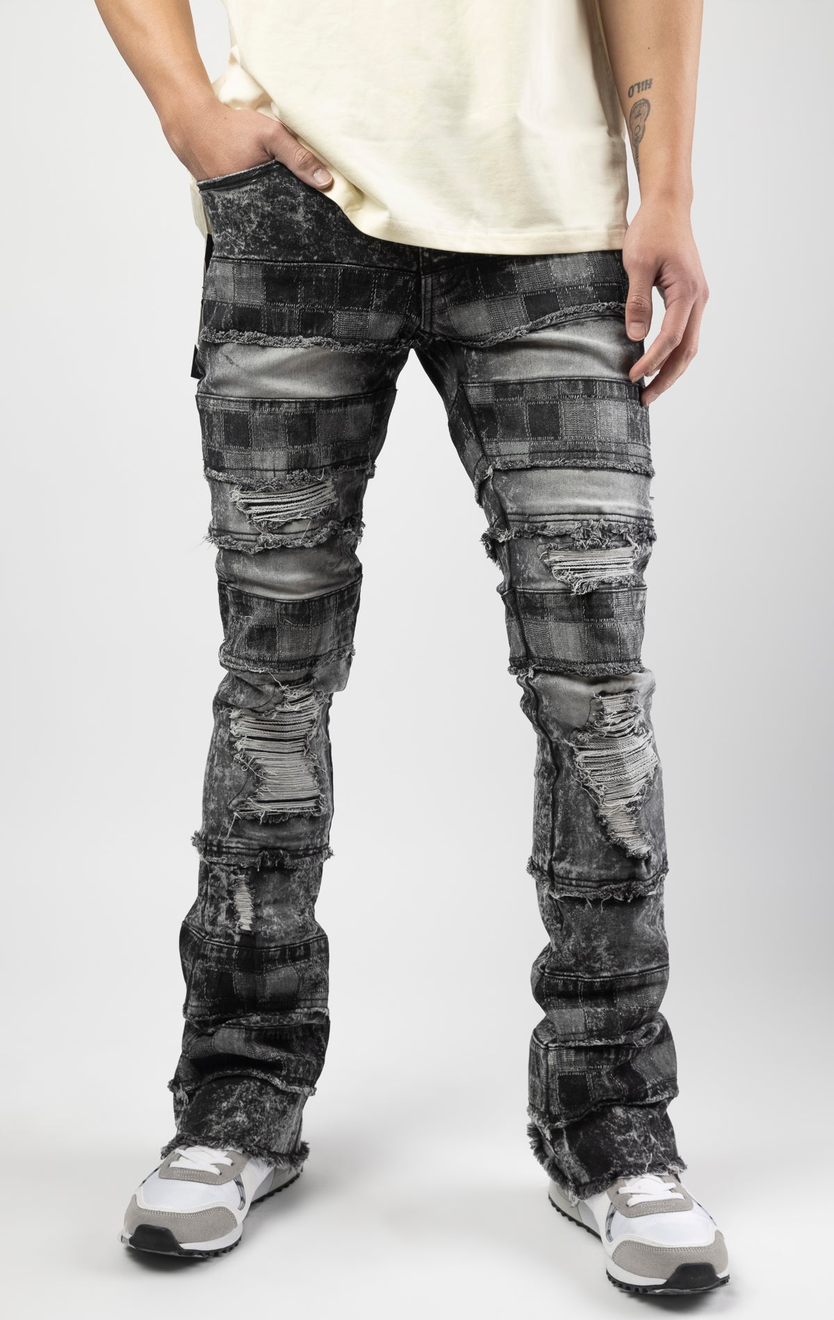 Black wash iconic stacked jeans crafted from high-quality, durable denim fabric consisting of 98% cotton and 2% spandex with a semi flare silhouette and a length of 35"-37". Featuring a distinctive ripped and repair design with pocket patches and a multi-