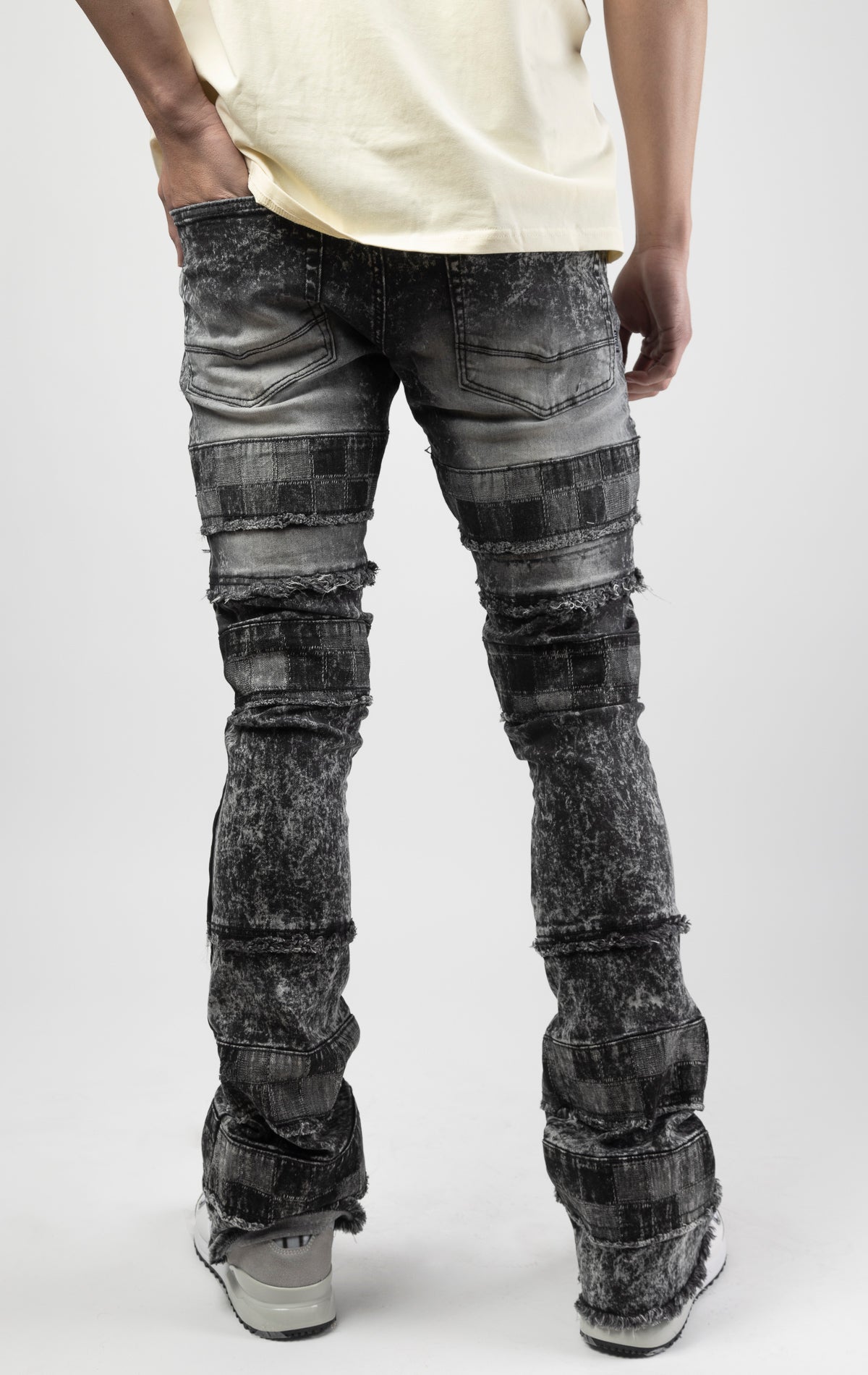 Black wash iconic stacked jeans crafted from high-quality, durable denim fabric consisting of 98% cotton and 2% spandex with a semi flare silhouette and a length of 35"-37". Featuring a distinctive ripped and repair design with pocket patches and a multi-