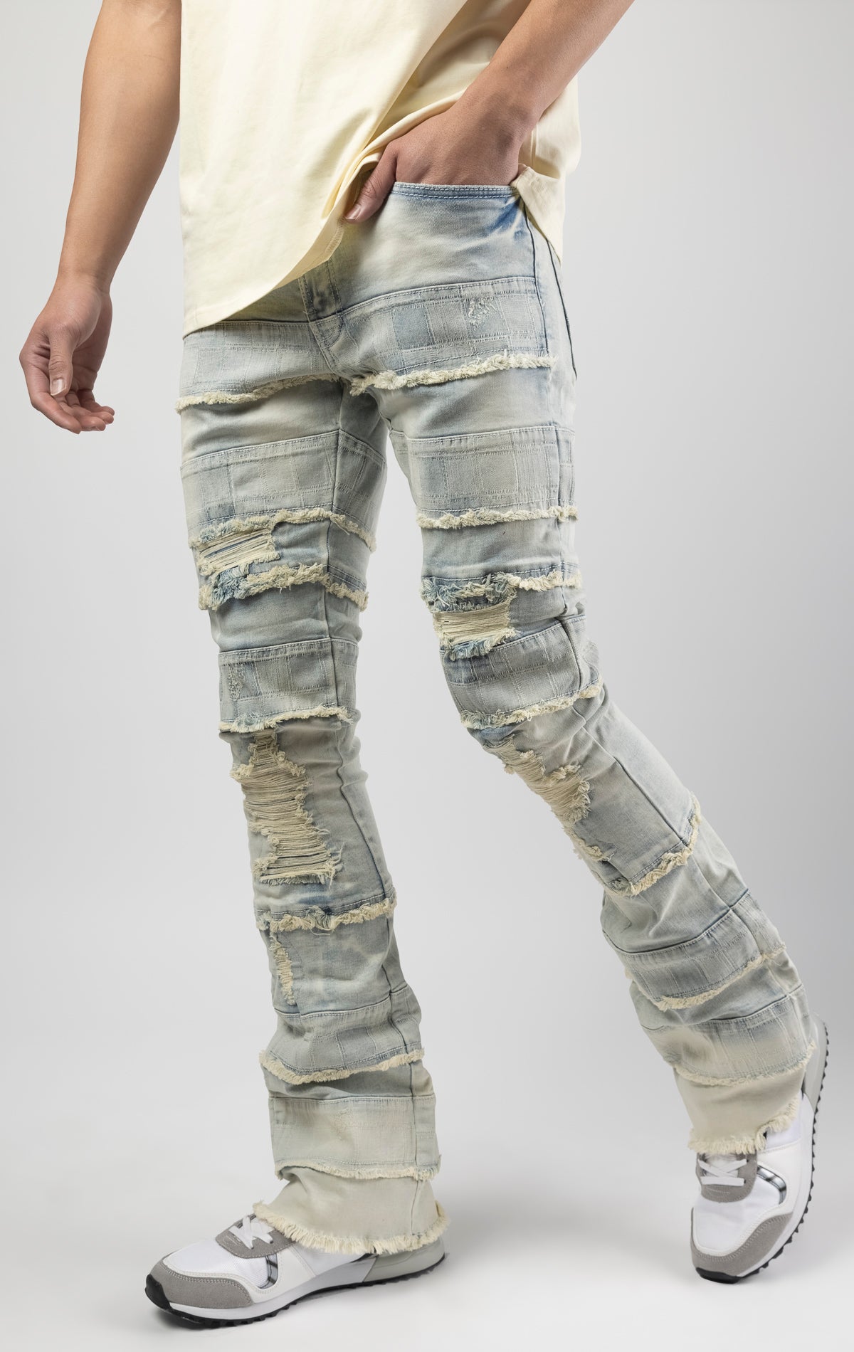 Light wash iconic stacked jeans crafted from high-quality, durable denim fabric consisting of 98% cotton and 2% spandex with a semi flare silhouette and a length of 35"-37". Featuring a distinctive ripped and repair design with pocket patches and a multi-