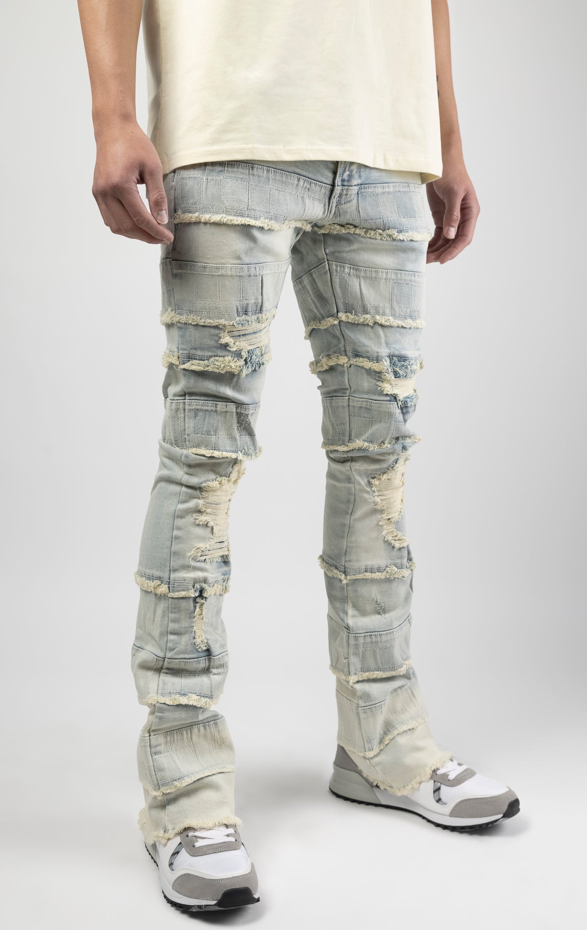 Light wash iconic stacked jeans crafted from high-quality, durable denim fabric consisting of 98% cotton and 2% spandex with a semi flare silhouette and a length of 35"-37". Featuring a distinctive ripped and repair design with pocket patches and a multi-