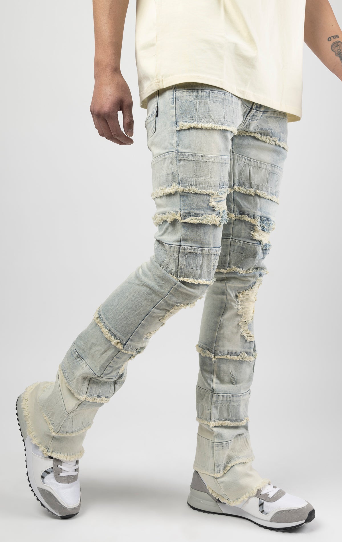 Light wash iconic stacked jeans crafted from high-quality, durable denim fabric consisting of 98% cotton and 2% spandex with a semi flare silhouette and a length of 35"-37". Featuring a distinctive ripped and repair design with pocket patches and a multi-