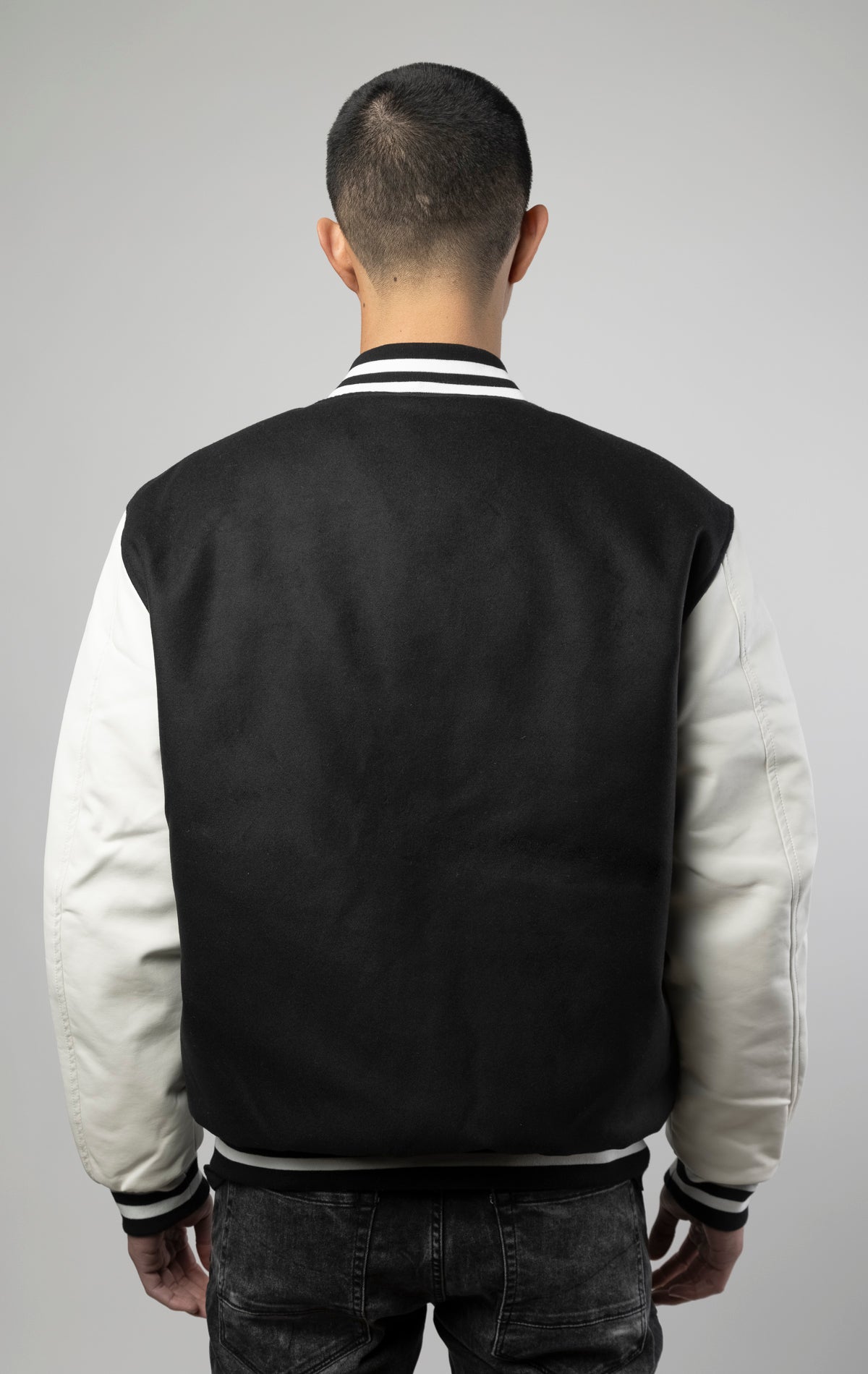 Black and white Los Angeles varsity jacket featuring a sleek button closure, ribbed cuffs, and a satin lining for added comfort.