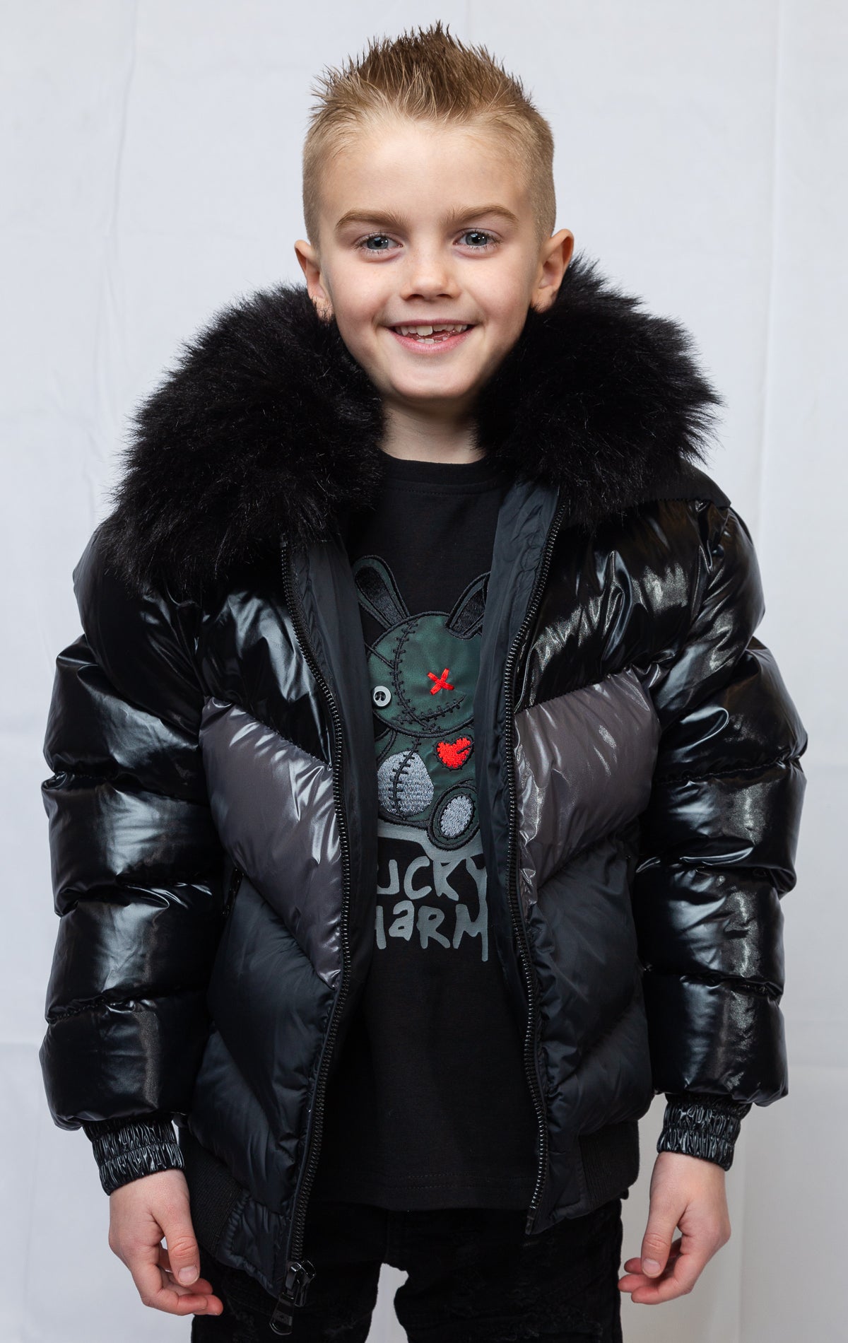 This  kids' puffer jacket features a 100% nylon laqué shell, quilted padding, and 100% polyester lining. It also includes branded Jordan Craig zippers, dual side pockets with zipper closure, and a removable faux jackal fur collar. 