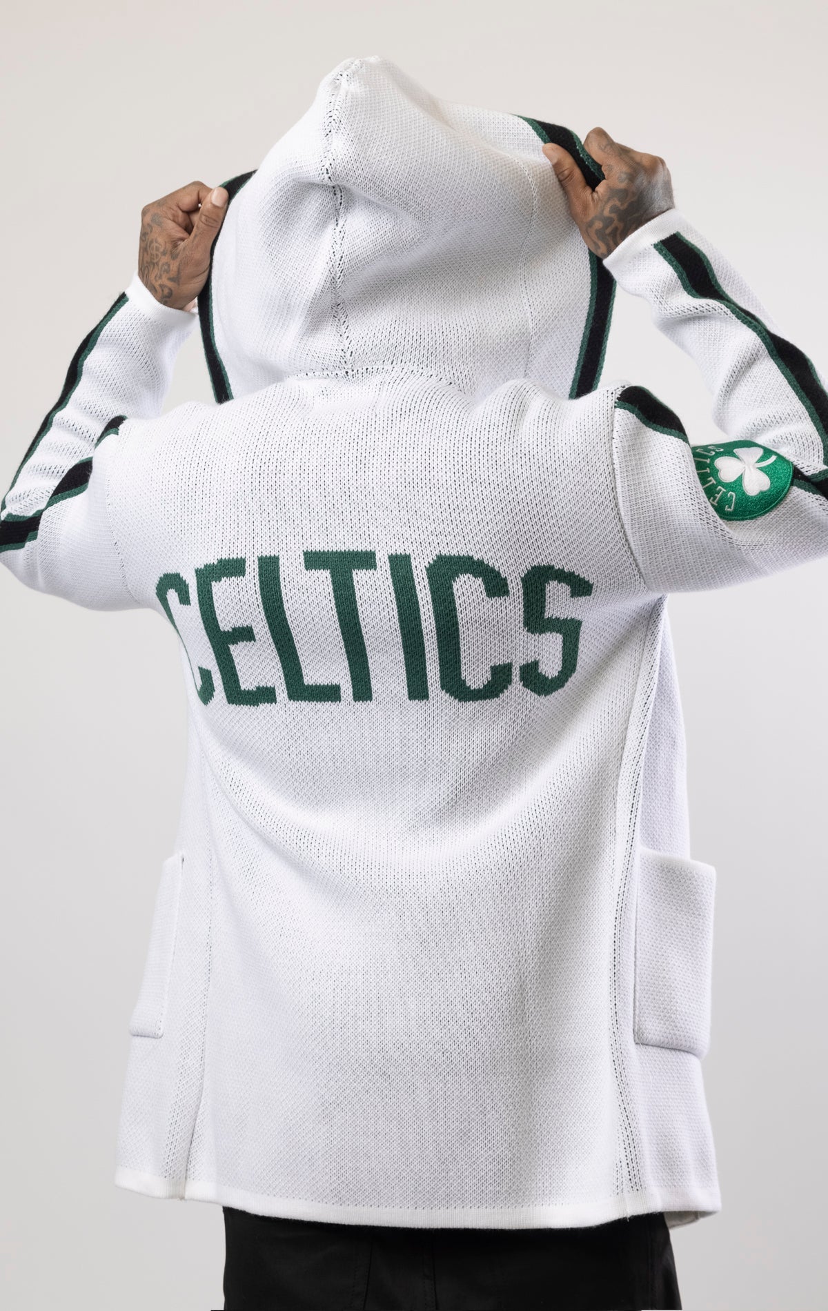 Upgrade your game day look with this Boston Celtics Cardigan Sweater. This cozy jacket is designed with a stylish three-quarter length and boasts bold team branding on the front, back, and sleeve. Complete with a full-zip closure, attached hood, and front