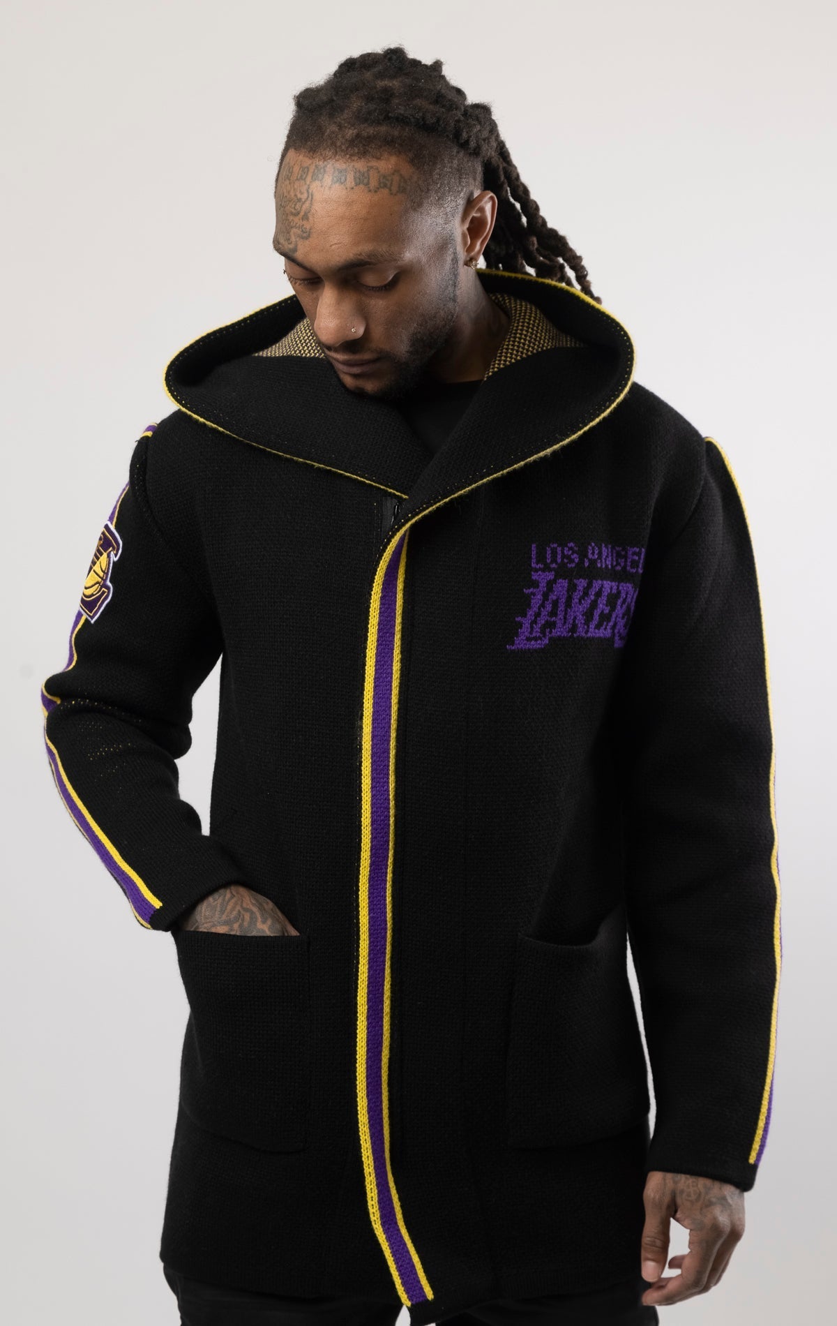 black LA LAKERS Cardigan Sweater. This cozy jacket is designed with a stylish three-quarter length and boasts bold team branding on the front, back, and sleeve. Complete with a full-zip closure, attached hood, and front pockets, this knit sweater offers b