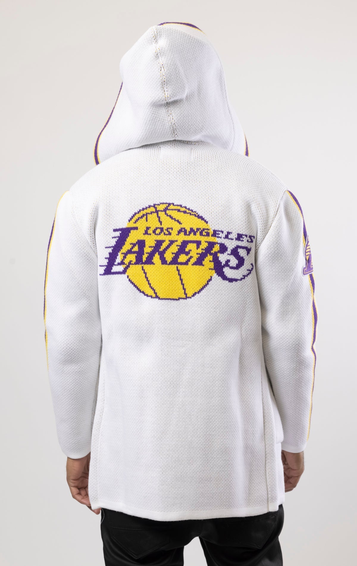 White LA LAKERS Cardigan Sweater. This cozy jacket is designed with a stylish three-quarter length and boasts bold team branding on the front, back, and sleeve. Complete with a full-zip closure, attached hood, and front pockets, this knit sweater offers b