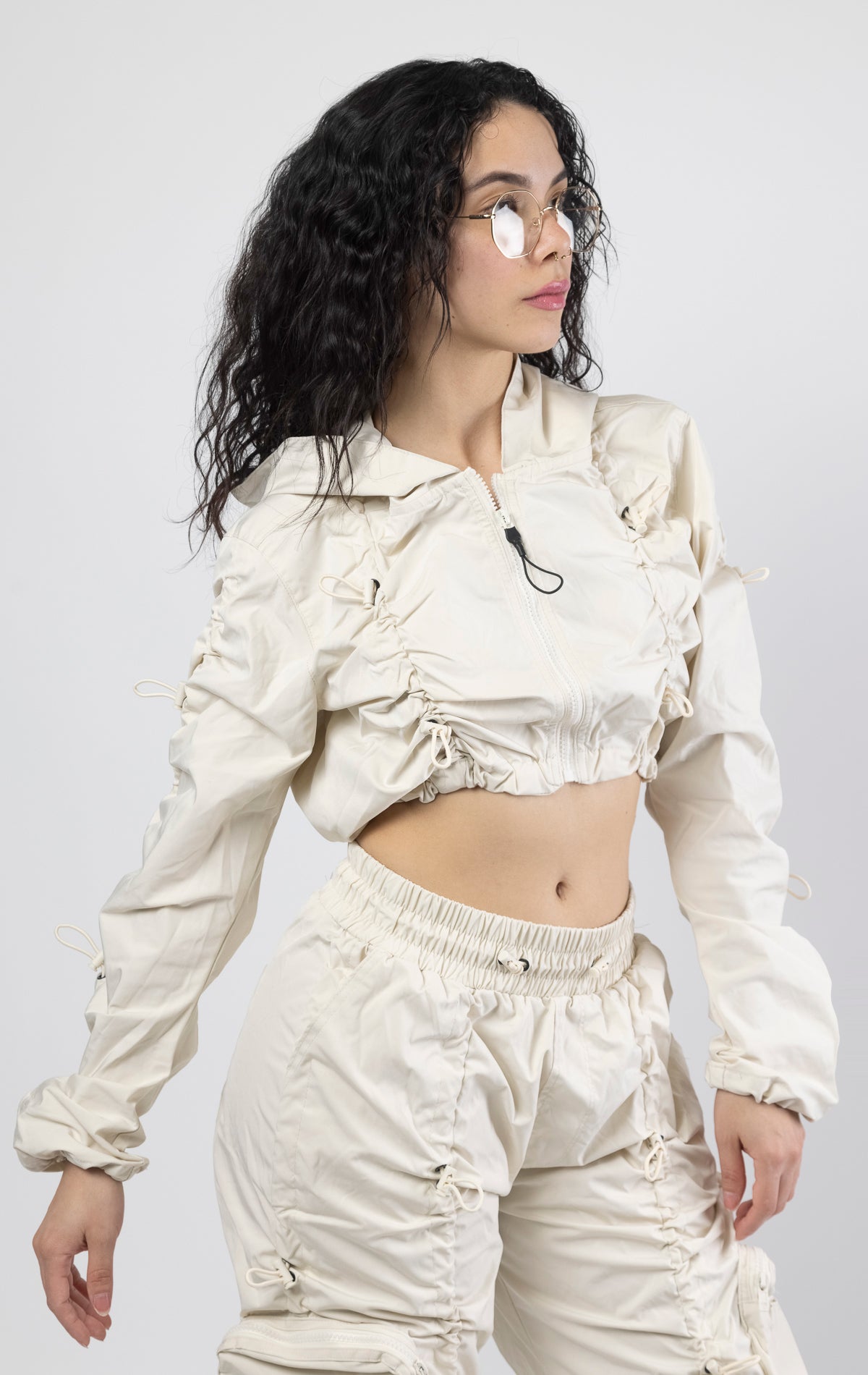 Oatmeal Cropped windbreaker full zip jacket. Fit: Carter metal eyelets3-D cargo pocket with self strap, adjustable bottom opening, and cuffed hem