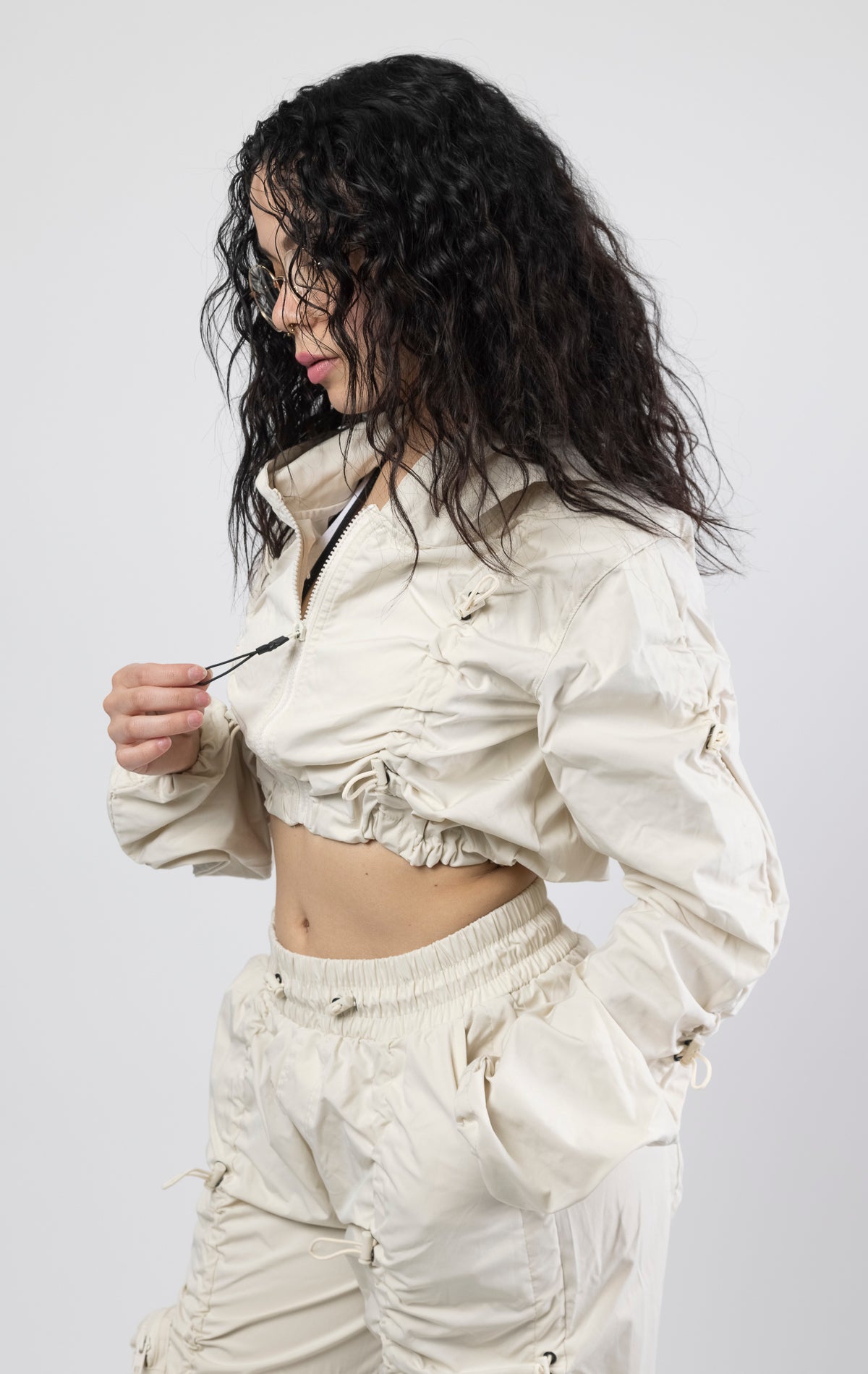 Oatmeal Cropped windbreaker full zip jacket. Fit: Carter metal eyelets3-D cargo pocket with self strap, adjustable bottom opening, and cuffed hem