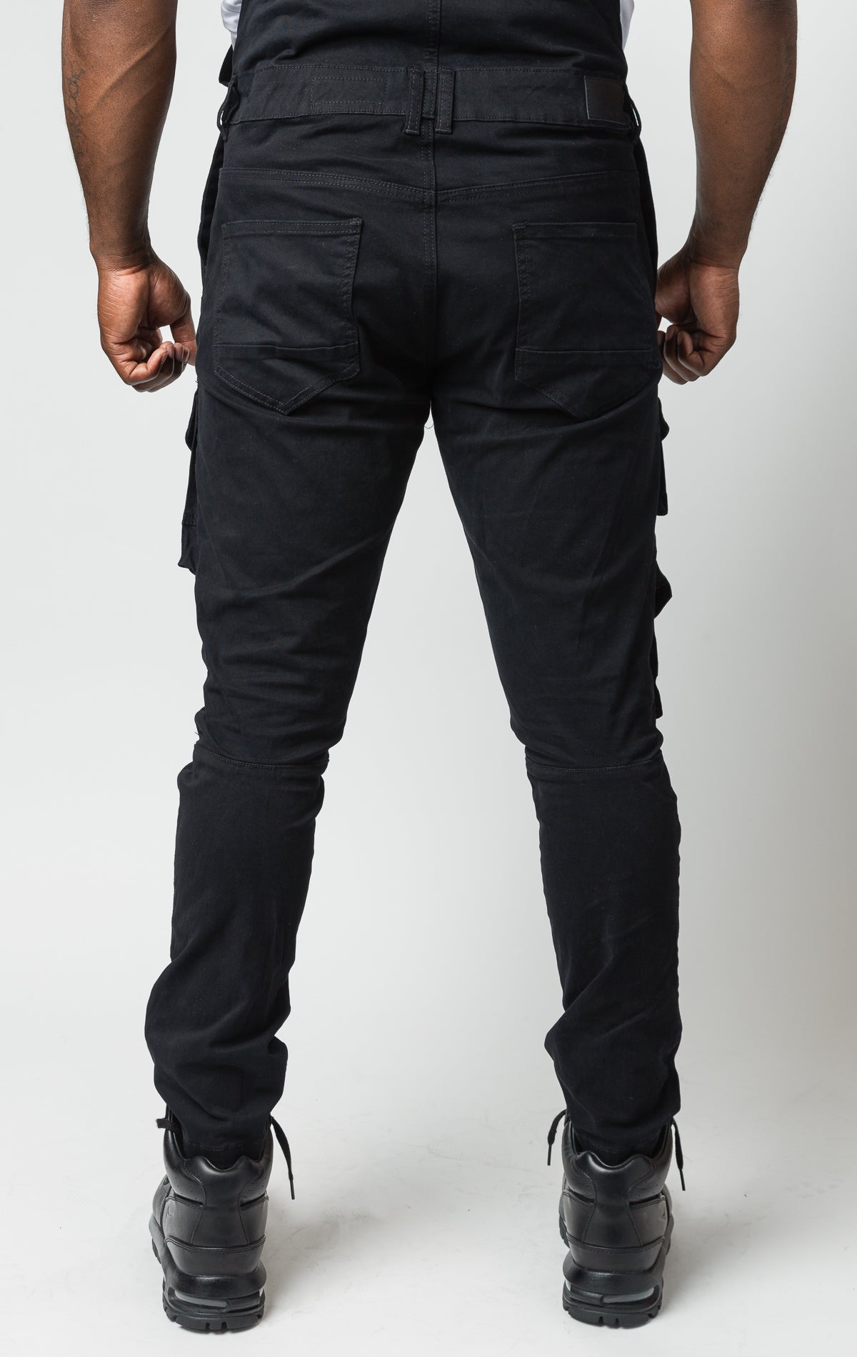 black Cotton twill overalls with cargo pockets and adjustable shoulder straps.