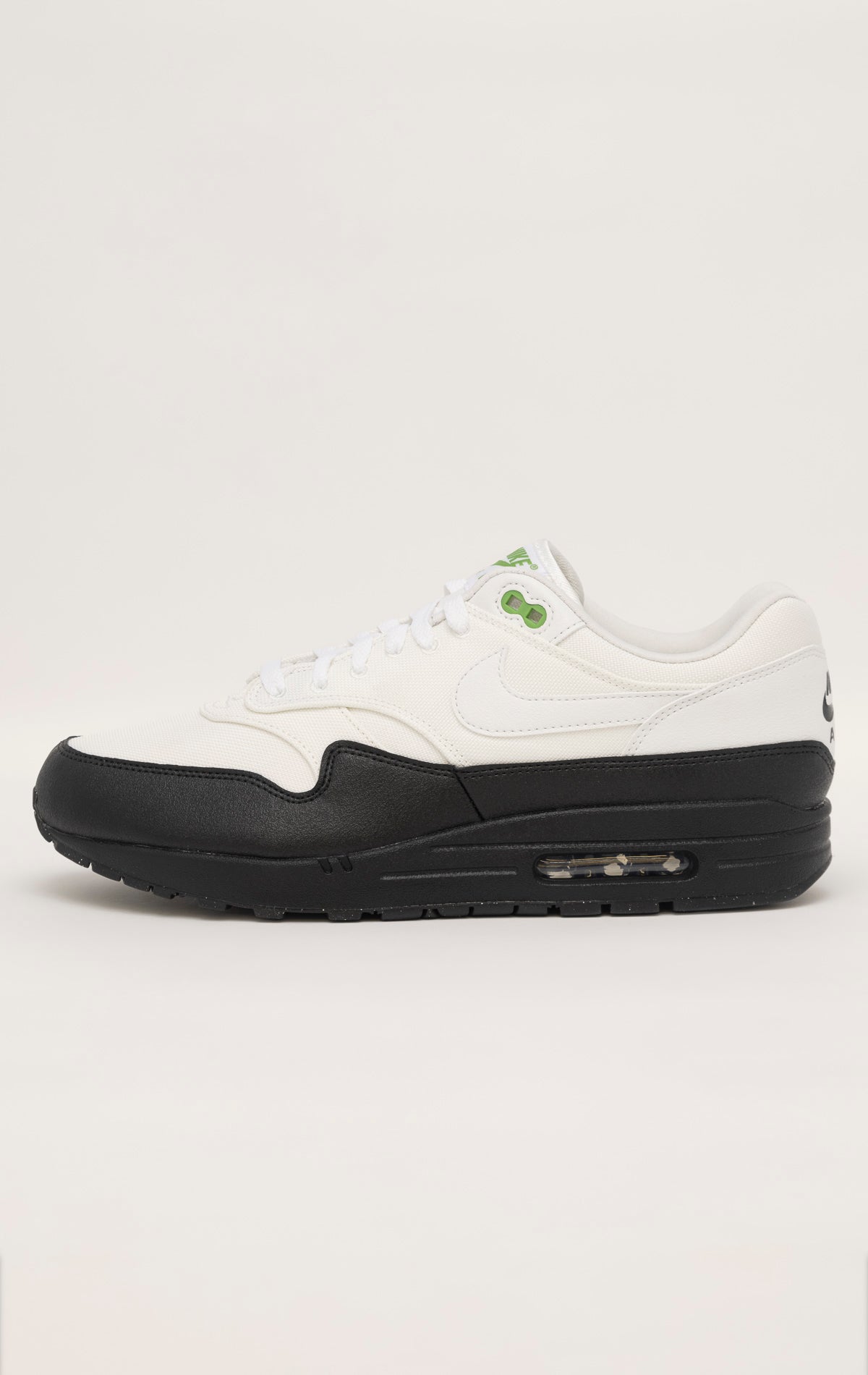 Green and white Nike Air Max 1 SE sneakers with a canvas upper, leather accents, and visible Air unit in the heel and forefoot