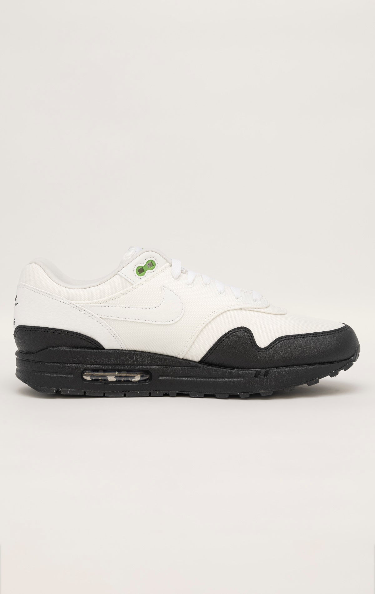 Green and white Nike Air Max 1 SE sneakers with a canvas upper, leather accents, and visible Air unit in the heel and forefoot