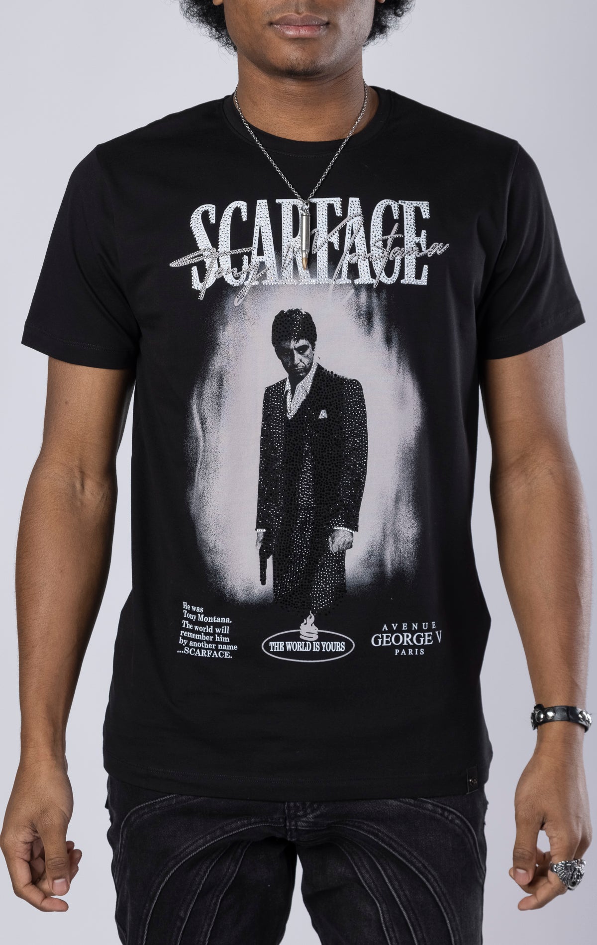 black Scarface Crewneck Tee. Features a crewneck, short sleeves, and a bold Scarface graphic. Made from a blend of 95% cotton and 5% lycra.