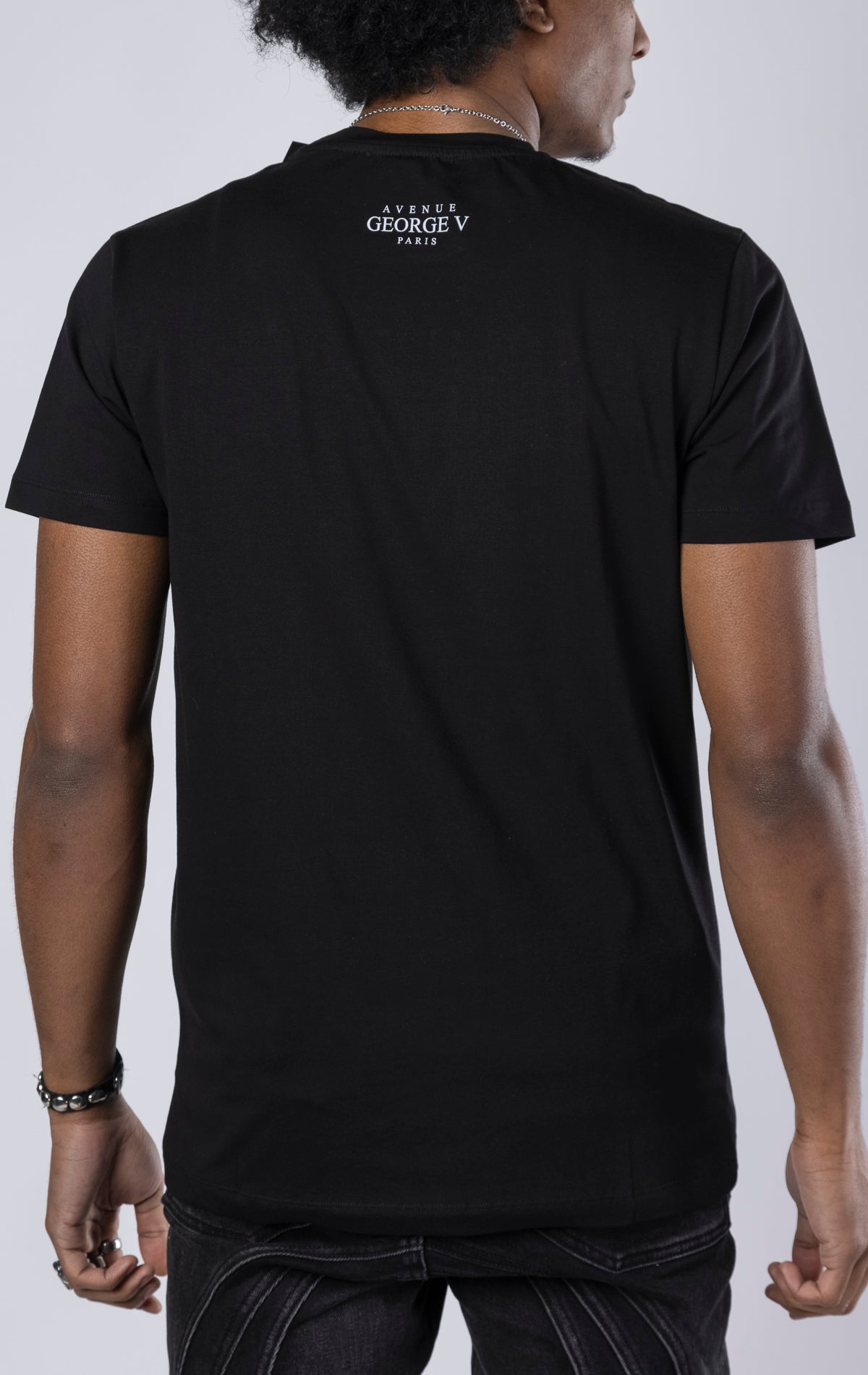 black Scarface Crewneck Tee. Features a crewneck, short sleeves, and a bold Scarface graphic. Made from a blend of 95% cotton and 5% lycra.