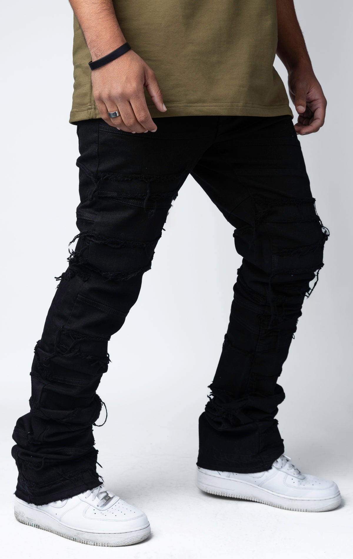 Edgy flare jeans feature a unique heavy wash, rip and repair design, and patches and abrasions throughout.