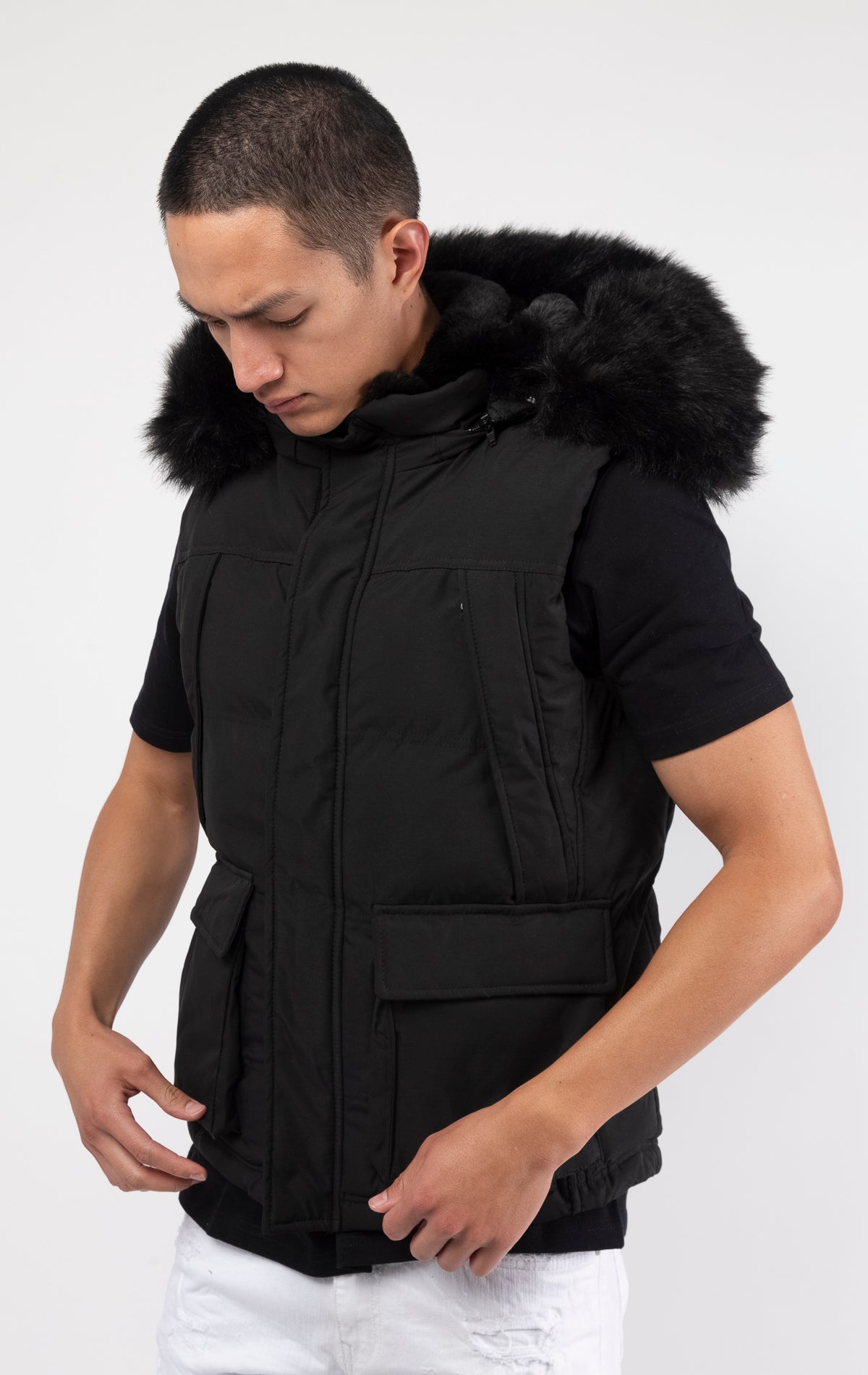 Black Faux fur-lined hooded jacket made of a water-resistant polyester shell featuring a removable hood with a removable faux fox fur trim. The hood and front of the jacket are lined with faux rabbit fur for superior warmth. The jacket has JC branded zipp