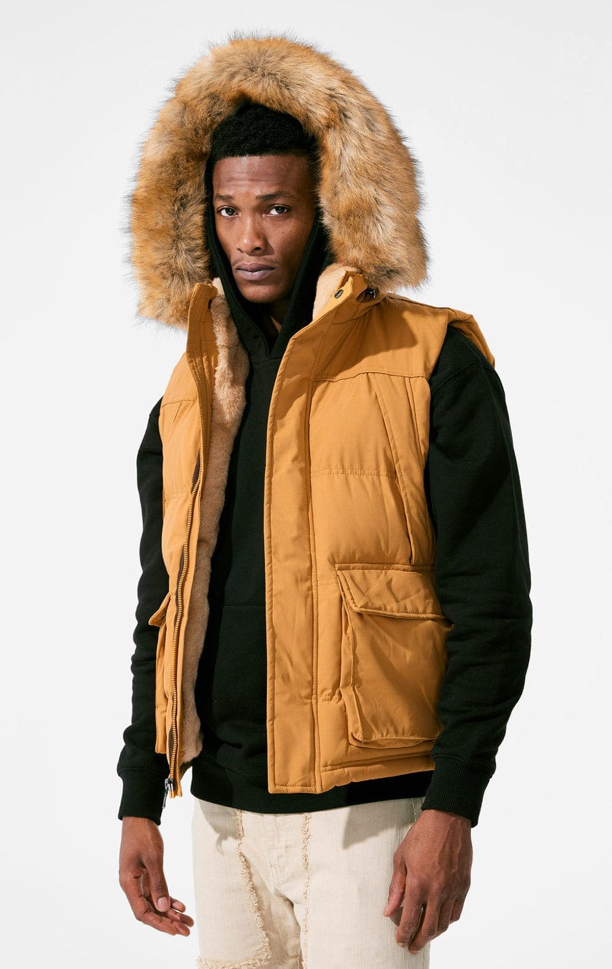 Wheat color Faux fur-lined hooded jacket made of a water-resistant polyester shell featuring a removable hood with a removable faux fox fur trim. The hood and front of the jacket are lined with faux rabbit fur for superior warmth. The jacket has JC brande