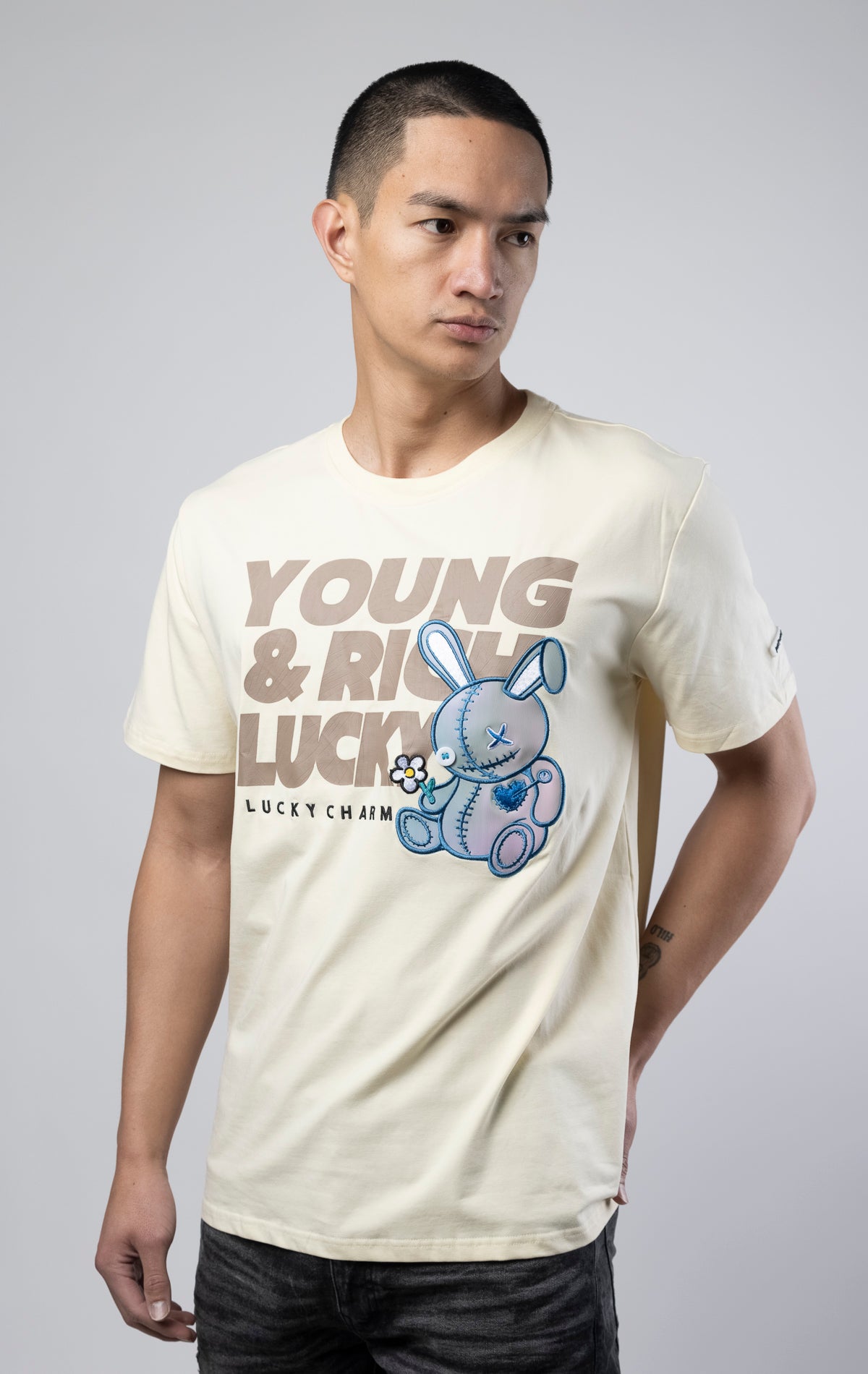 Stylish off white T-shirt featuring a motivational 'Young, Rich, and Lucky' slogan