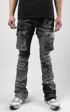 Black camo Extended length flare pant with a regular rise for maximum stacks. Skinny fit with hand-smearing and speckled paint splatter throughout. Rip and repair detailing, accompanied by cut & sewn woodland camouflage twill patches. Stitching repairs and deep front pocket bags, perfect for large smart phones.