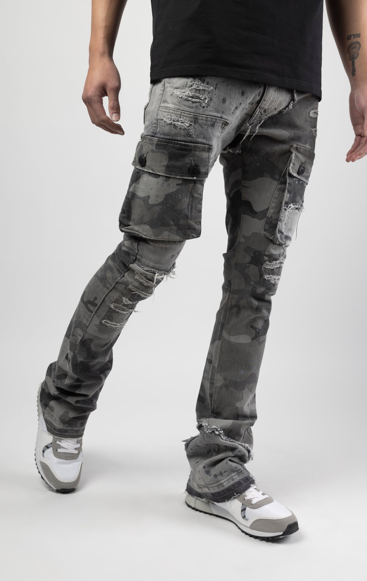 Overcast camo extended length flare pant with a regular rise for maximum stacks. Skinny fit with hand-smearing and speckled paint splatter throughout. Rip and repair detailing, accompanied by cut & sewn woodland camouflage twill patches. Stitching repairs and deep front pocket bags, perfect for large smart phones.