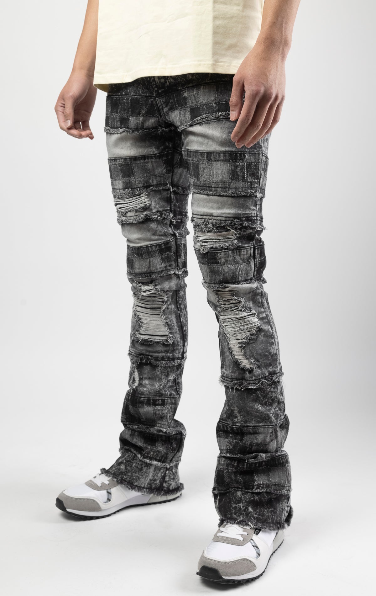 Black wash iconic stacked jeans crafted from high-quality, durable denim fabric consisting of 98% cotton and 2% spandex with a semi flare silhouette and a length of 35"-37". Featuring a distinctive ripped and repair design with pocket patches and a multi-tone dye throughout, these urban-inspired pants are true to size