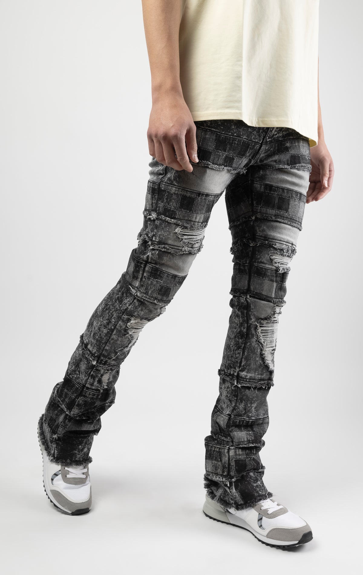 Black wash iconic stacked jeans crafted from high-quality, durable denim fabric consisting of 98% cotton and 2% spandex with a semi flare silhouette and a length of 35"-37". Featuring a distinctive ripped and repair design with pocket patches and a multi-tone dye throughout, these urban-inspired pants are true to size