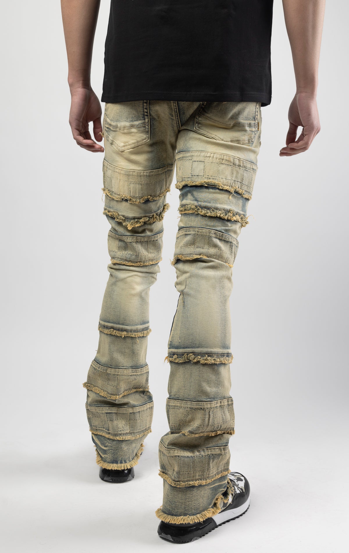 Dirt wash iconic stacked jeans crafted from high-quality, durable denim fabric consisting of 98% cotton and 2% spandex with a semi flare silhouette and a length of 35"-37". Featuring a distinctive ripped and repair design with pocket patches and a multi-tone dye throughout, these urban-inspired pants are true to size