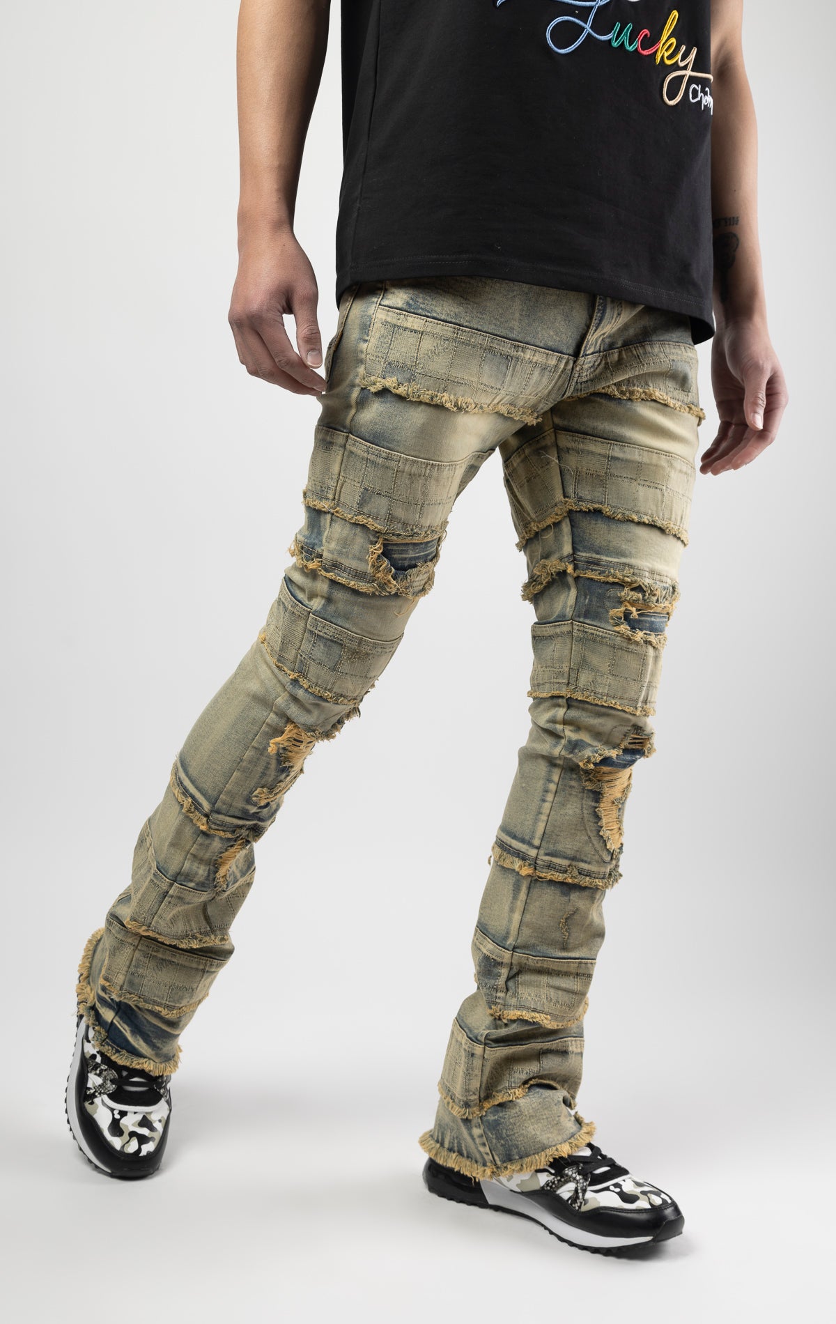 Dirt wash iconic stacked jeans crafted from high-quality, durable denim fabric consisting of 98% cotton and 2% spandex with a semi flare silhouette and a length of 35"-37". Featuring a distinctive ripped and repair design with pocket patches and a multi-tone dye throughout, these urban-inspired pants are true to size