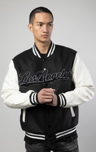 Black and white Los Angeles varsity jacket featuring a sleek button closure, ribbed cuffs, and a satin lining for added comfort.
