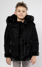 Black jacket lined with plush faux shearling throughout the body and sleeves. It also features shearling-accented pockets, a horn toggle front closure, and vegan suede straps with a buckle at the neck. For added convenience, a detachable faux fox fur hood with a zipper is included. This product is also available for adults.