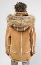 Praline jacket lined with plush faux shearling throughout the body and sleeves. It also features shearling-accented pockets, a horn toggle front closure, and vegan suede straps with a buckle at the neck. For added convenience, a detachable faux fox fur hood with a zipper is included. This product is also available for adults.