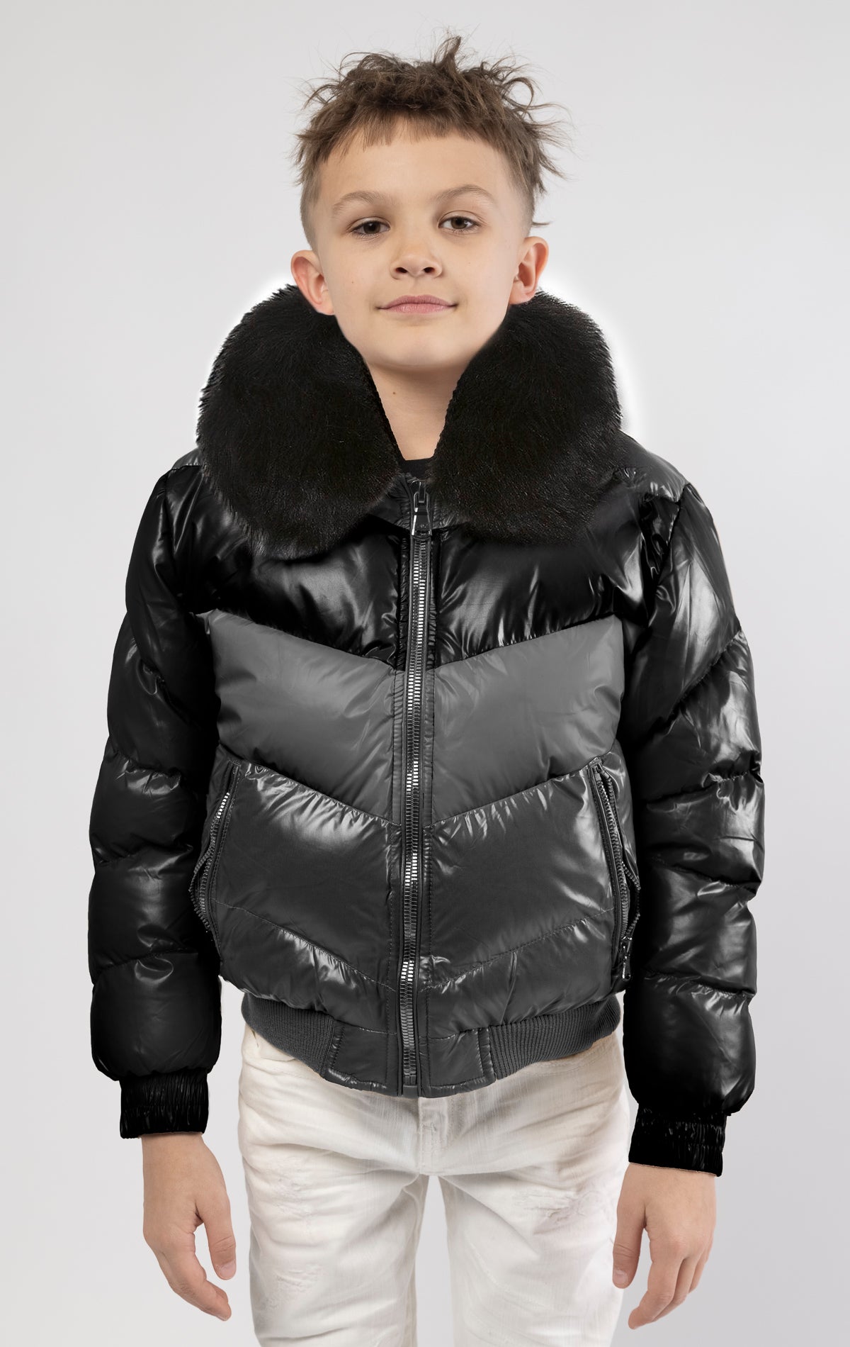 This kids' puffer jacket features a 100% nylon laqué shell, quilted padding, and 100% polyester lining. It also includes branded Jordan Craig zippers, dual side pockets with zipper closure, and a removable faux jackal fur collar.