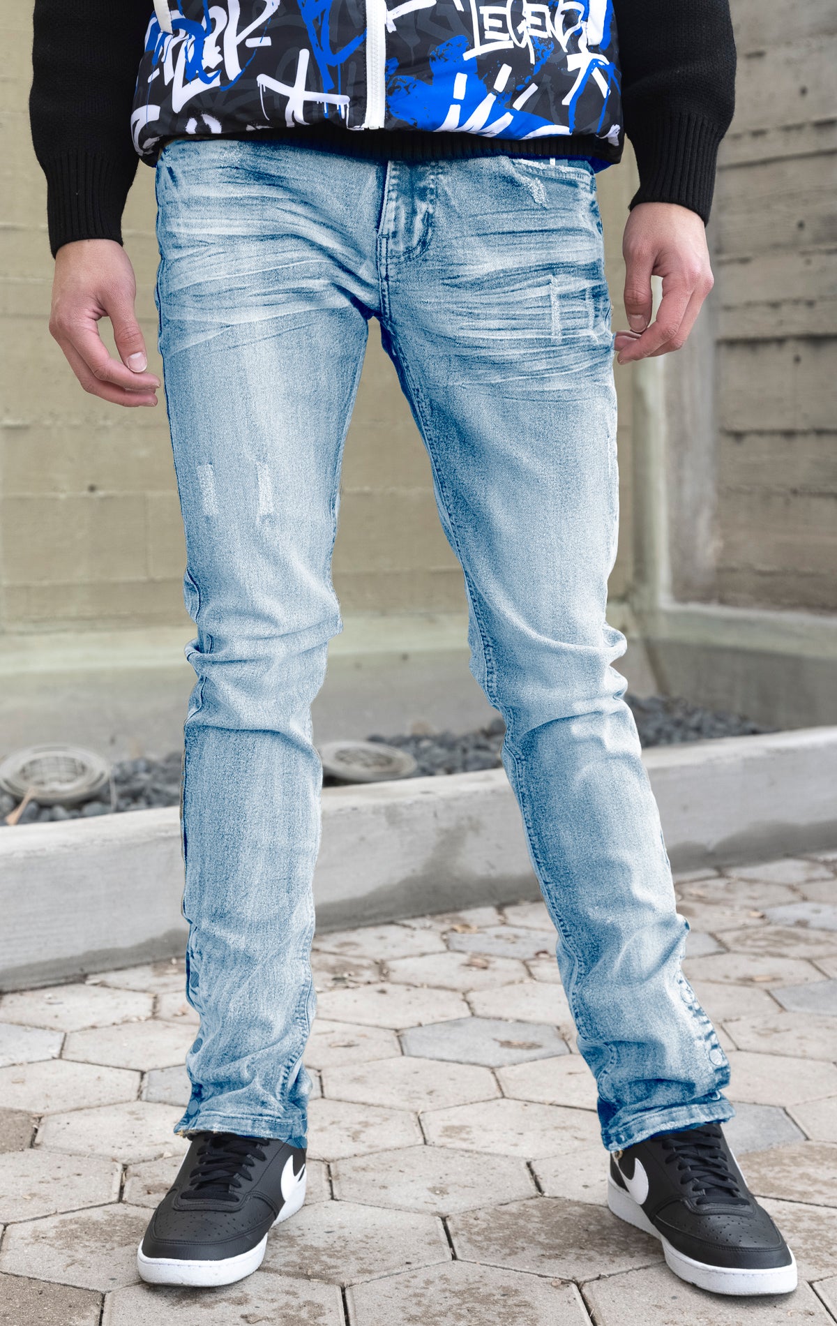 Ice Blue tint denim featuring distressed detailing throughout, a skinny fit, stretch denim, and a buttoned flare.