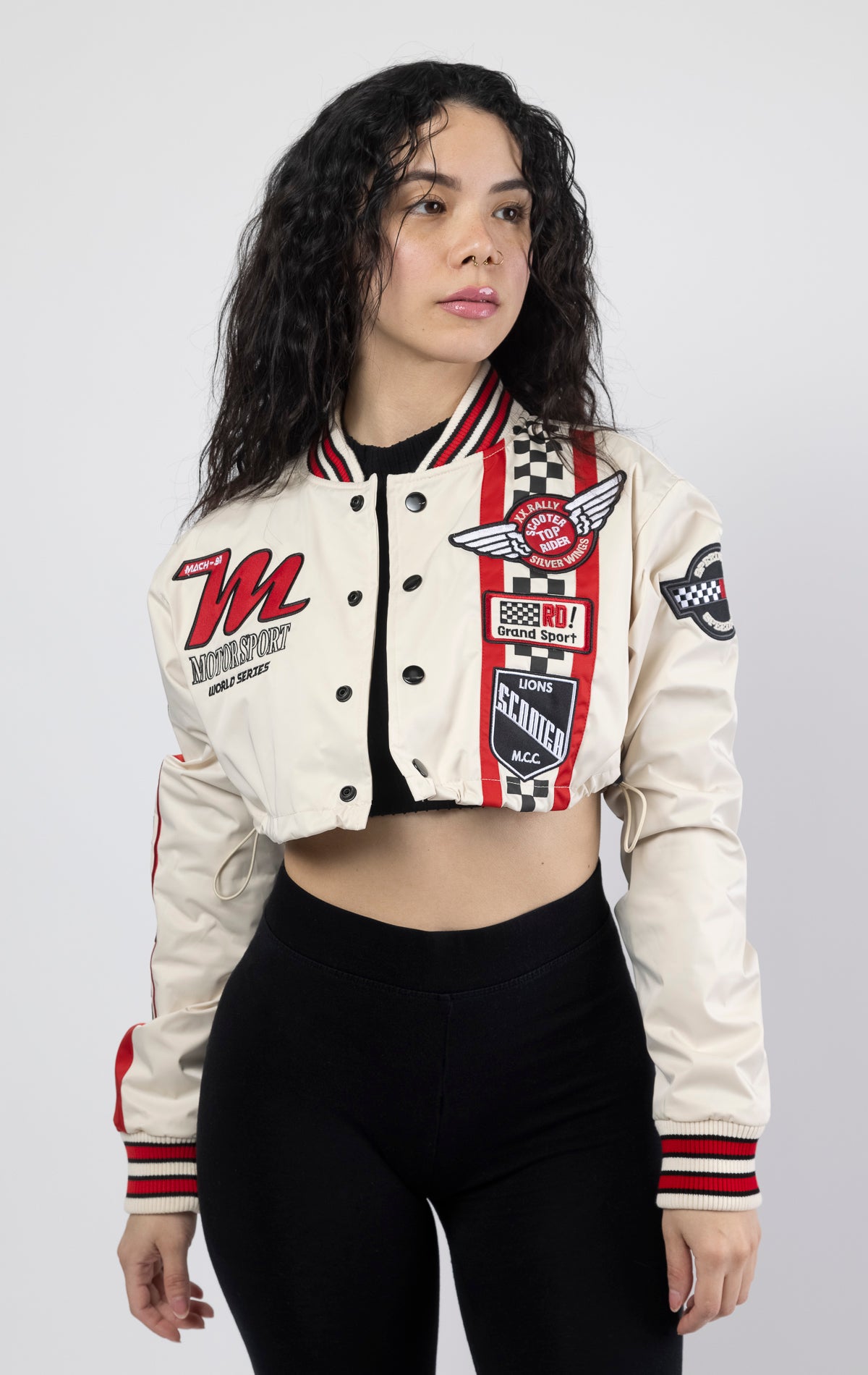 High-performance cropped jacket. Made with breathable coated polyester in a bold color. Featuring coated snap buttons and a bungee adjustable bottom opening. Quality meets style with multi twill/embroidered patch details.