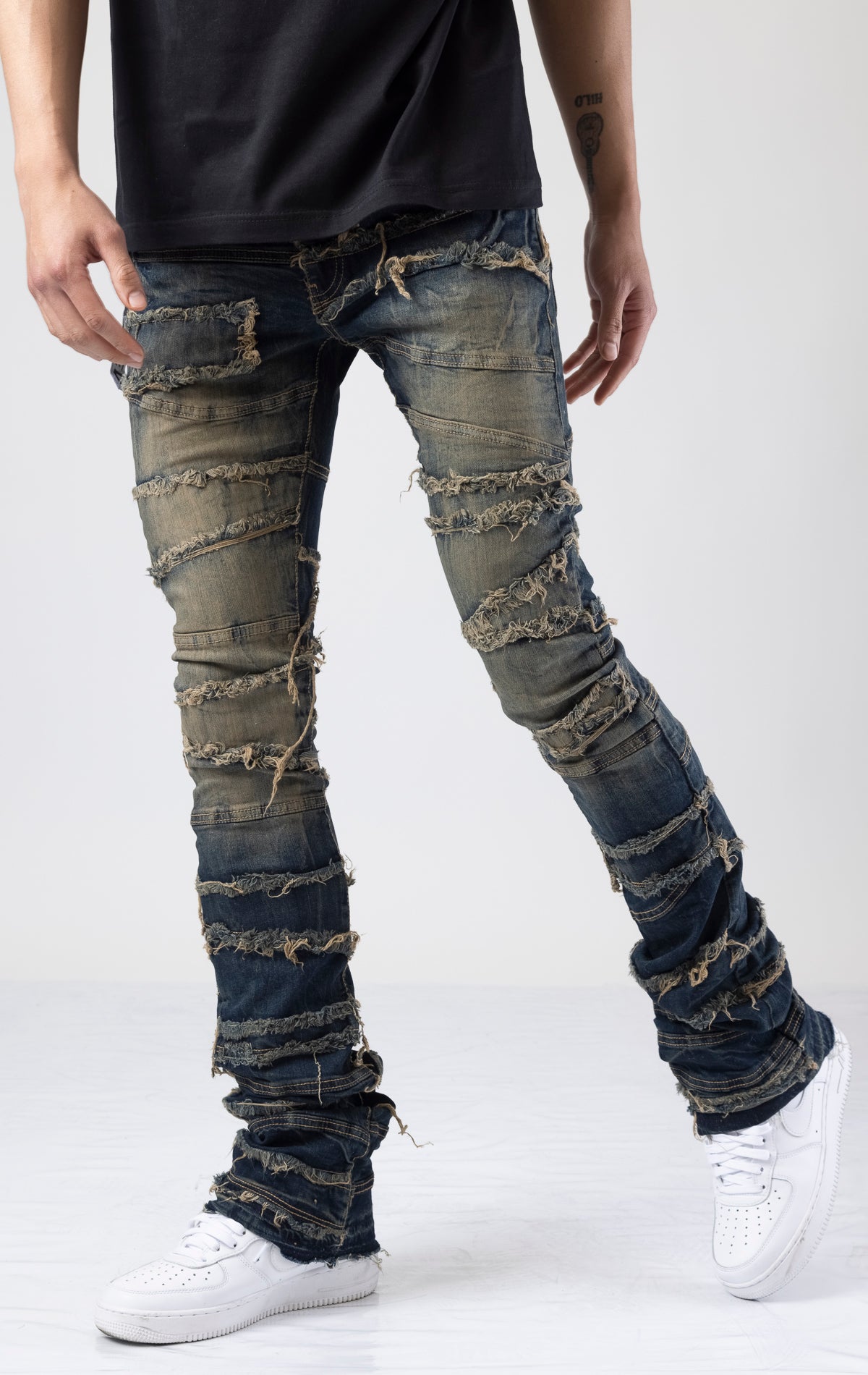 Normal rise jeans with longer inseam for ultimate stacking effect. Sewn panels with unfinished hems and distressed details throughout.