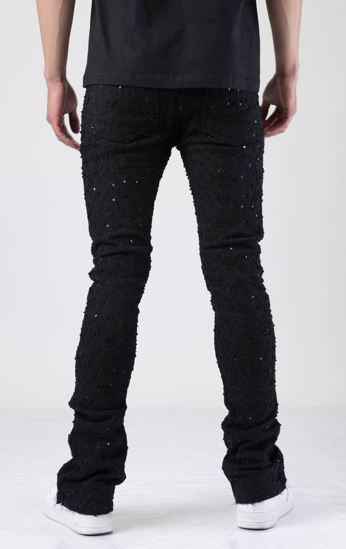 Black embellished stacked flared jeans in black.
