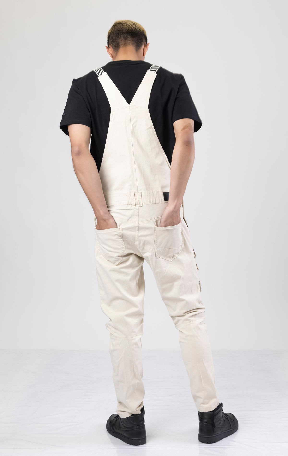 Latte color Cotton twill overalls with cargo pockets and adjustable shoulder straps.