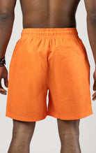 Orange board shorts with an elastic waist and graphic print