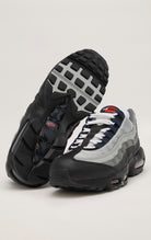 A black Nike Air Max 95 sneaker with a wavy mesh upper and visible Air cushioning units in the heel and forefoot. Anthracite and smoke grey accents contrast with pops of track red for a bold look.