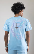 Sky blue t-shirt with a digital photo print on the front and back, embroidered text on the front, and a 3D metallic dagger embroidered on the back.