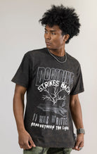 A DOCTRINE STRIKE BACK T-shirt featuring a high-definition digital graphic print across the front. The shirt is made from 100% cotton and has a vintage-washed look.