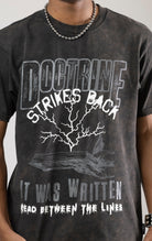 A DOCTRINE STRIKE BACK T-shirt featuring a high-definition digital graphic print across the front. The shirt is made from 100% cotton and has a vintage-washed look.