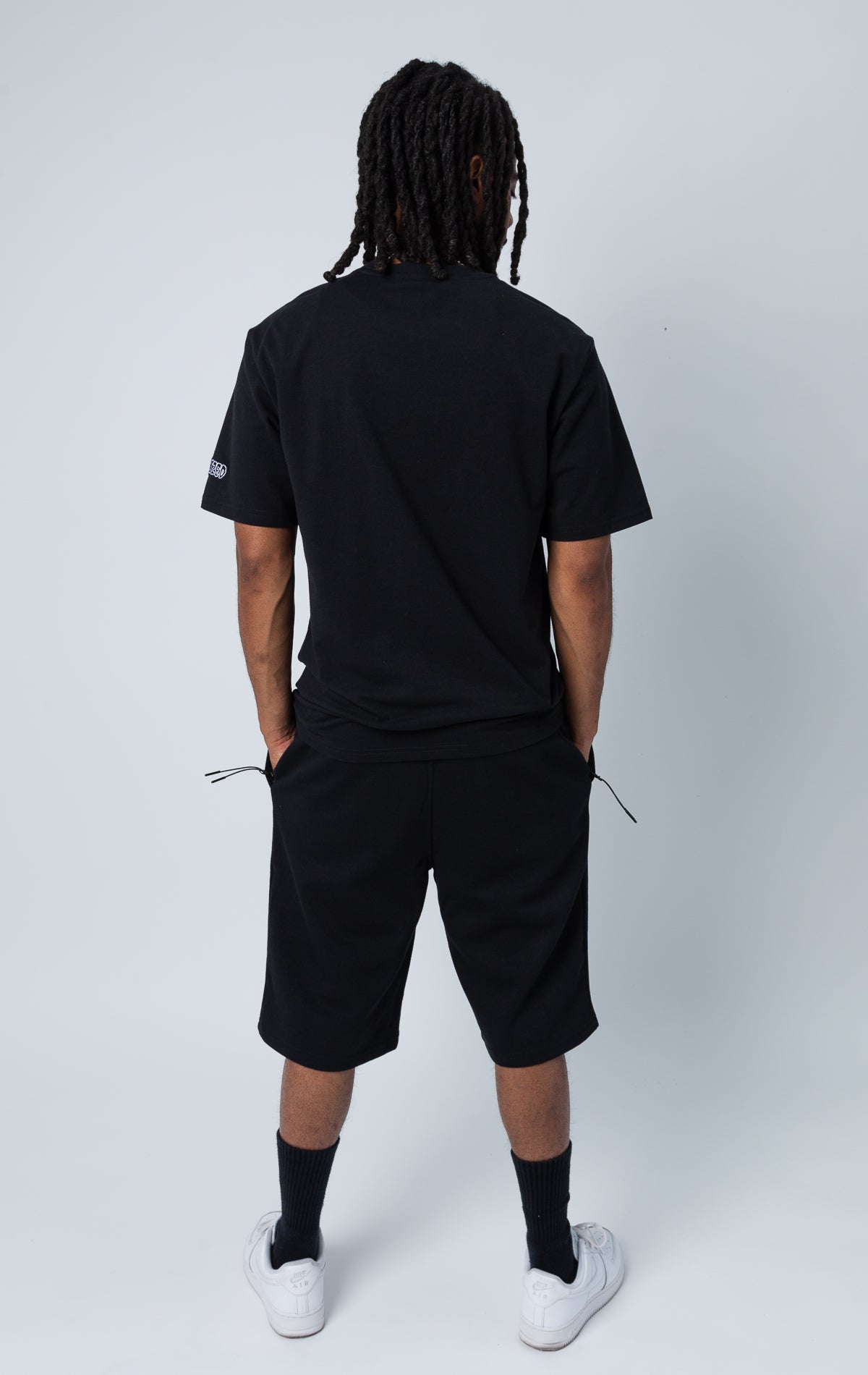 Back side of black set of shirt and shorts with "LOVE" graphic.
