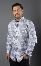 Man wearing a stylish shirt with contrasting patterns and sophisticated details, made from high-quality, performance stretch cotton fabric, perfect for both dressy and casual occasions.