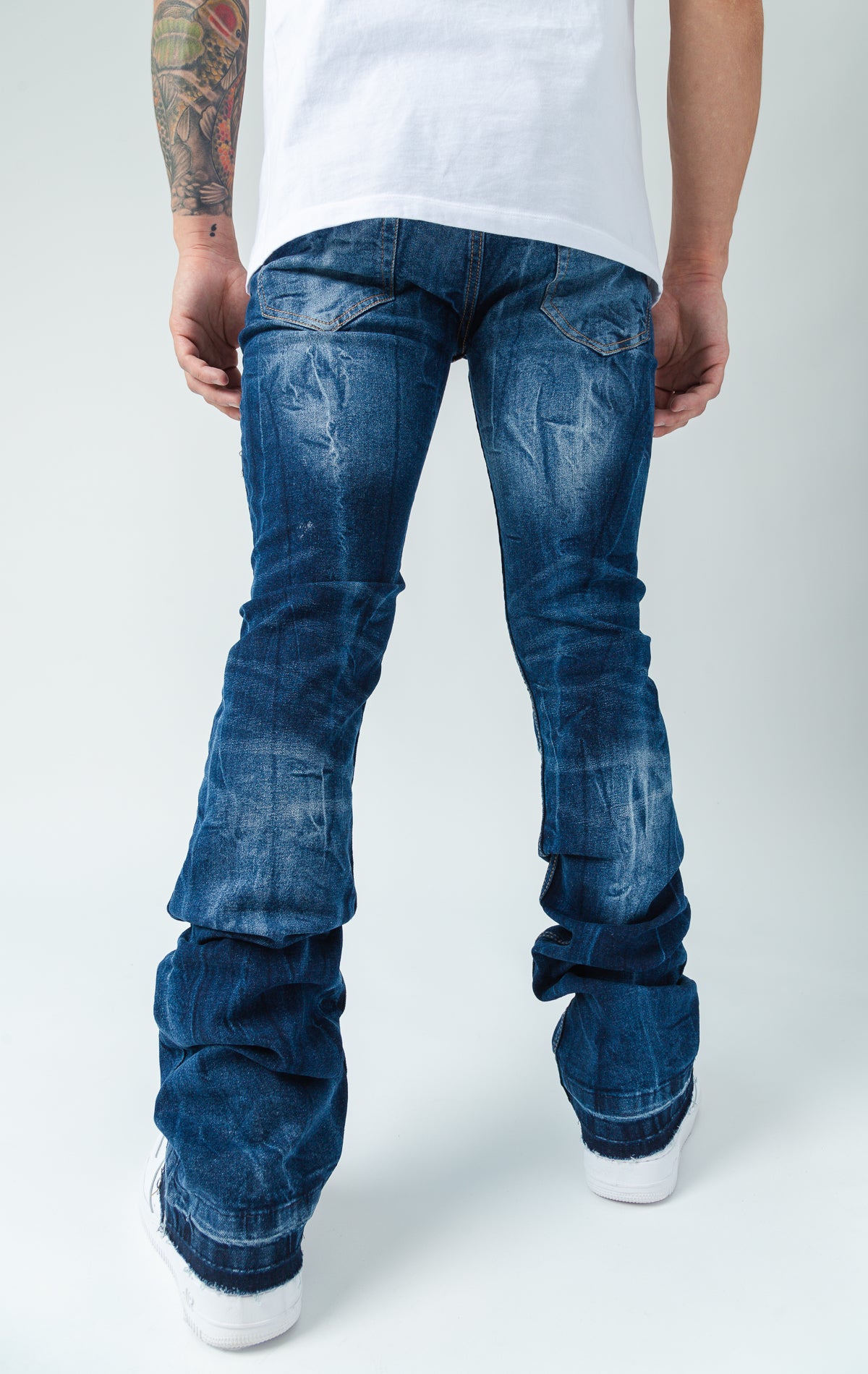 Back side of worn down stacked denim in blue