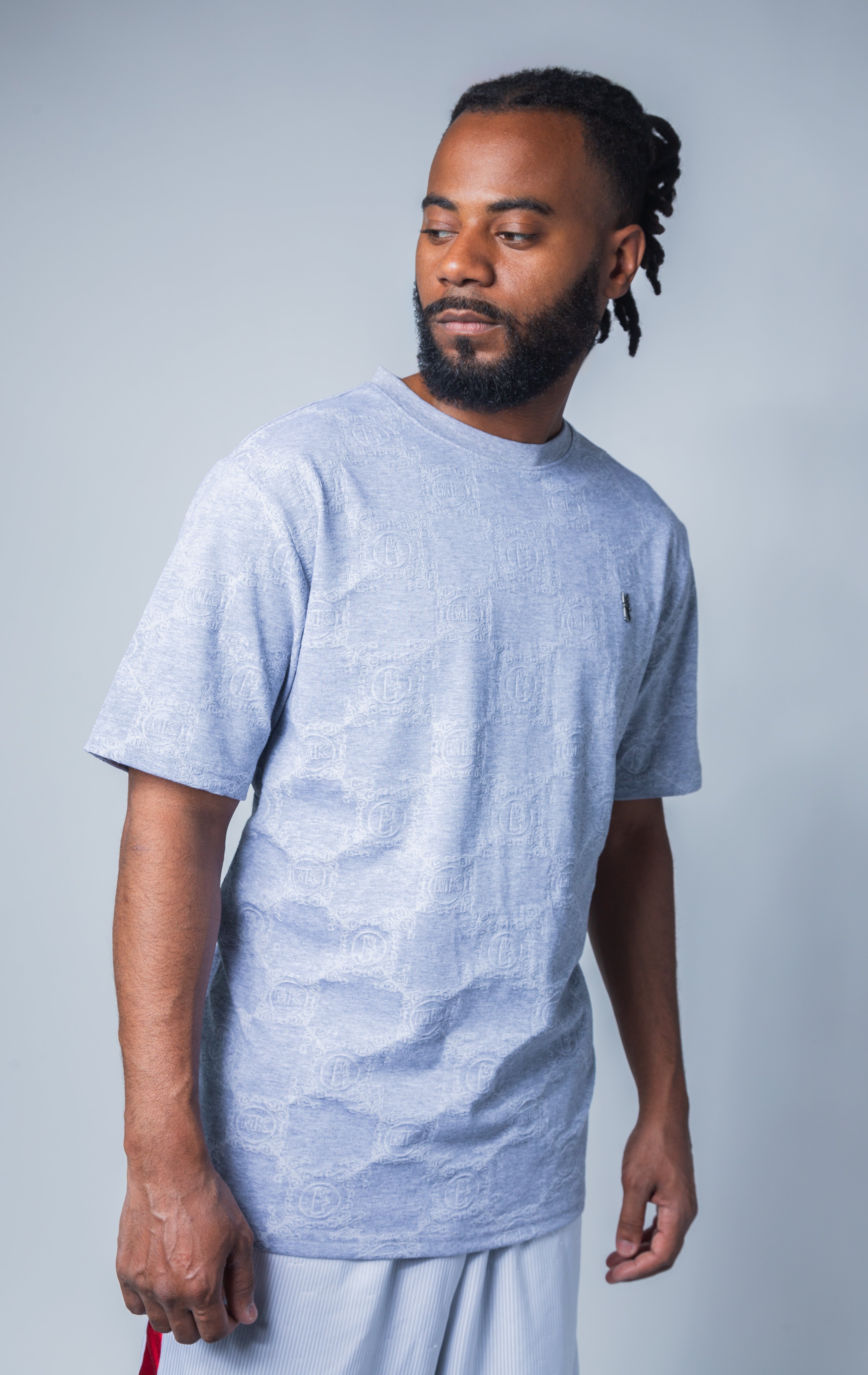 grey all-over tonal embossed pattern, short sleeve t-shirt with logo hardware on left side of chest