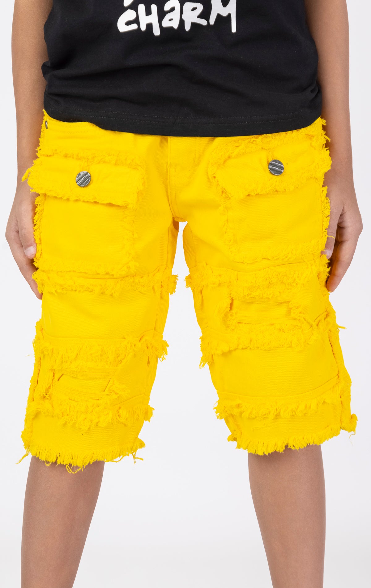 Kids Patchwork Layered Shorts in yellow. Features a playful patchwork design, two front pockets, and two back pockets. Designed for comfortable and active play.