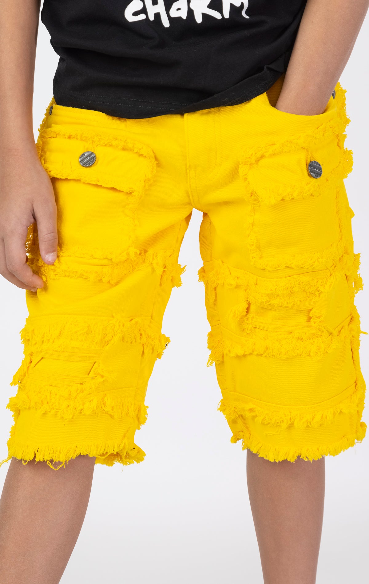 Kids Patchwork Layered Shorts in yellow. Features a playful patchwork design, two front pockets, and two back pockets. Designed for comfortable and active play.